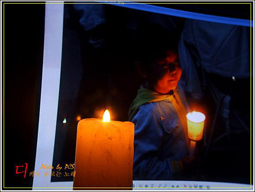 서울광장에서 아이가 촛불을 들고 있는 장면을 찍어 집 컴퓨터 화면으로 보면서 촛불을 밝혀 찍은 사진입니다.