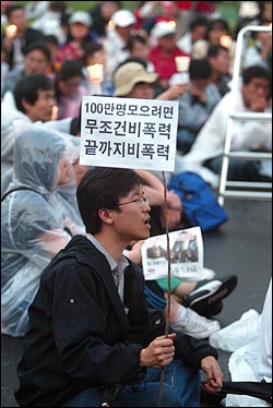  미국산 쇠고기 수입 전면개방 반대 72시간 릴레이 농성이 마무리 된 가운데 8일 저녁 서울시청앞 광장에서 32차 촛불문화제가 열리고 있다. 한 시민이 비폭력을 주장하는 종이깃발을 들고 있다.