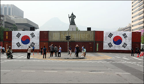 10일 오후 서울 세종로 사거리 북쪽길에 콘테이너 장벽이 설치된 가운데 대형 태극기 2개가 콘테이너 벽에 걸려있다.
