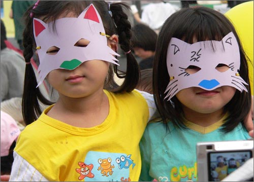 10일 저녁 대전역 광장에서 열린 '6월 민주항쟁 21주년 대전충남 기념식'에 참가한 아이들이 쥐 잡는 고양이 가면을 쓰고 포즈를 취하고 있다.