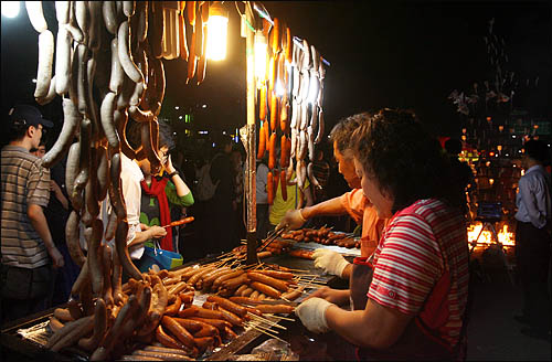 6.10 항쟁 기념일인 10일 밤늦도록 서울 광화문 일대에서 미국산 쇠고기 수입반대 촛불집회가 이어지는 가운데 세종로 사거리는 소시지와 핫도그 등 야식시장이 문전성시를 이루고 있다.