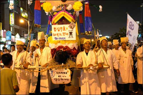 전국농민회총연맹 경북도연맹 참여자들이 상복을 입고, 꽃상여를 메고 곡을 하며 행진을 하고 있다.