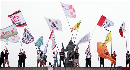 미국산쇠고기 수입 전면 재협상 촉구 및 국민무시 이명박 정권 심판 100만 촛불대행진에 참석했던 학생, 시민들이 11일 새벽 서울 세종로네거리에서 컨테이너 박스 위에 올라가 깃발을 흔들고 있다.