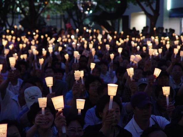 촛불문화제 참여 시민들이 "이명박 정권 퇴진"을 외치며 촛불을 치켜들고 있다.