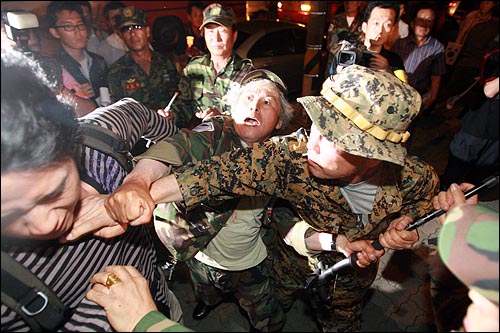 13일 저녁 고엽제전우회 회원들이 여의도 KBS본사앞에서 이명박 정권 공영방송 장악음모 저지를 위한 촛불집회를 열고 있는 시민에게 주먹을 날리고 있다.