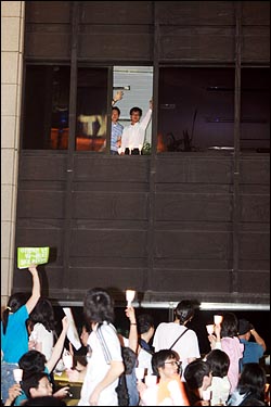 13일 저녁 이명박 정권의 공영방송 장악 움직임에 맞서 '공영방송 사수'를 주장하는 시민들이 여의도 KBS 본사를 에워싸고 촛불시위를 벌이자, 건물안에 있던 직원들이 창가에 촛불을 밝히며 손을 흔들고 있다.
