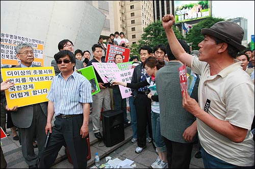  서경석 목사(기독교사회책임 공동대표)와 보수단체 회원들이 14일 오후 서울 파이낸스 빌딩 앞에서 미국산 쇠고기 수입 반대 촛불시위는 국가 장래를 위해 전혀 바람직하지 않다며 촛불시위에 반대하는 시위를 벌이던 중 미국산 쇠고기 수입 반대하는 한 시민이 항의를 하고 있다.