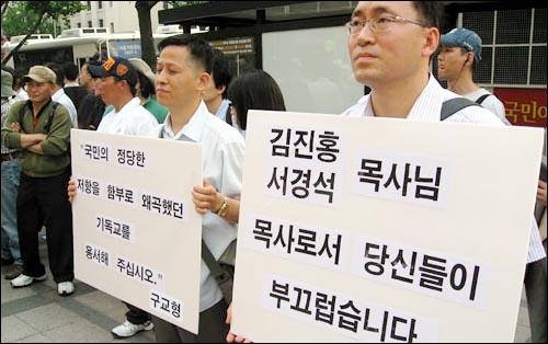  14일 김종환·구교형 두 목사는 서경석 목사의 '촛불반대 시위'에 맞서 "김진홍·서경석 목사님, 목사로서 당신들이 부끄럽습니다"고 적힌 팻말을 들었다.