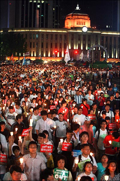 15일 저녁 서울시청앞 광장에서 열린 미국산쇠고기 수입 전면 재협상 촉구 및 이명박 정부 심판 39차 촛불문화제에 참석한 시민, 학생들이 촛불을 들고 거리행진에 나서고 있다.