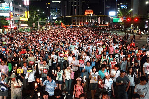  15일 저녁 서울시청앞 광장에서 열린 미국산쇠고기 수입 전면 재협상 촉구 및 이명박 정부 심판 39차 촛불문화제에 참석한 시민, 학생들이 촛불을 들고 거리행진에 나서고 있다.