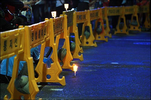 15일 저녁 서울시청앞 광장에서 열린 미국산쇠고기 수입 전면 재협상 촉구 및 이명박 정부 심판 39차 촛불문화제에 참석했던 시민들이 세종로네거리에서 폴리스라인에 가로 막히자 촛불을 폴리스라인 안쪽에 세워 놓고 있다.