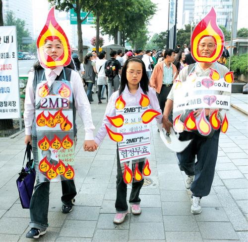 촛불모양의 분장을 한 가족이 집회에 참가하기 위해 광장으로 이동하고 있다.