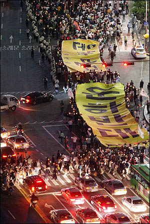지난해 6월 17일 미국산 쇠고기 수입과 대운하 건설에 반대하는 시민들이 서울시청 앞 광장에서 촛불집회를 연 뒤 '대운하반대' 대형 플래카드를 들고 거리행진을 하고 있다(자료 사진).