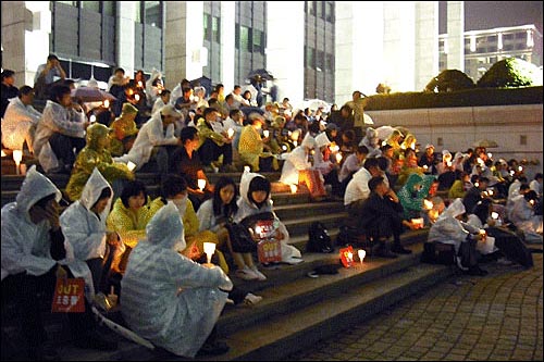 18일 밤 KBS 앞, 내리는 장맛비 속에서도 시민들은 촛불을 들었다.