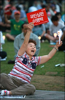  19일 저녁 서울시청앞 광장에서 <광우병과 의료민영화>를 주제로 열린 43차 촛불문화제에서 한 시민이 이명박 대통령을 규탄하며 함성을 외치고 있다.