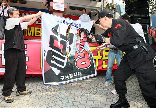 국민행동본부와 뉴라이트전국연합회원들이 20일 오후 서울 여의도 MBC 본사 앞에서 '광우병선동방송 MBC 규탄' 집회에서 광우병 조작 보도하는 MBC 규탄의 현수막을 찢는 퍼포먼스를 하고 있다.