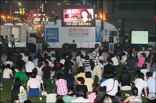 20일 밤 44차 촛불문화제에 참석했던 시민, 학생들이 행진을 마친 뒤 서울시청앞 광장에서 광우병대책회의쪽에서 준비한 마이클 무어 감독의 <식코>를 오마이뉴스 생중계 방송차량을 통해 관람하고 있다.