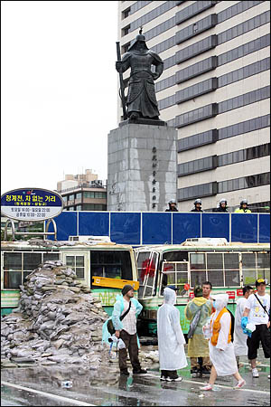  '48시간 비상국민행동' 세째날인 22일 아침 미국산 쇠고기 수입에 반대하는 시민들이 세종로 사거리를 막고 있는 차벽에 쌓은 모래주머니 계단 앞으로 지나고 있다.