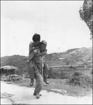 뜨거운 전우애로 부상단한 전우를 업고서 후송시키는 국군(1950. 7. 29.)