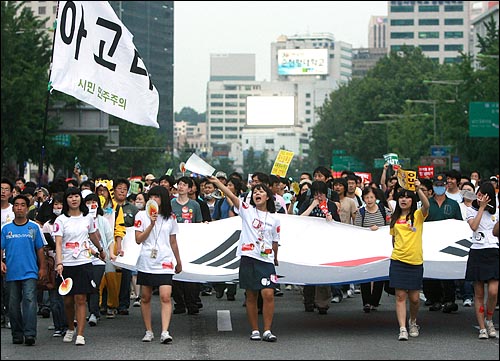 한미 쇠고기 재협상을 촉구하는 48시간 릴레이 농성이 벌어진 지난 21일 오후 다음 '아고라' 네티즌과 시민들이 대형태극기를 앞세우고 세종로네거리와 서울시청을 오가며 구호를 외치고 있다.