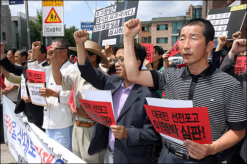 정운천 농림수산식품부장관이 미국산 쇠고기 수입위생조건 고시의 관보 게재를 요청한 가운데, 광우병국민대책회의가 24일 오후 청운동사무소 앞에서 "고시강행은 국민을 향한 전쟁선포"라며 항의하고 있다.