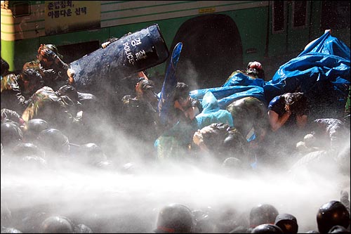 미국산쇠고기 수입위생조건 장관고시에 반대하며 시민, 학생들이 밤샘시위를 벌이는 가운데 26일 새벽 서울 새문안교회 뒤편에서 경찰이 시위대에게 살수차로 물을 뿌리고 있다.