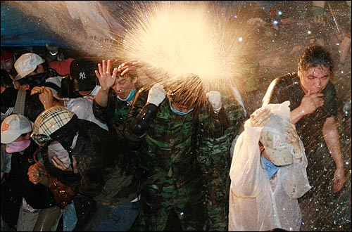 미국산쇠고기 수입위생조건 장관고시에 반대하는 학생과 시민들이 26일 새벽 서울 새문안교회 뒤편에서 밤샘시위를 벌이자 경찰들이 시위대에게 살수차로 물을 뿌리고 있다.