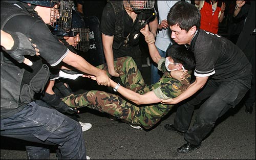 미국산쇠고기 수입위생조건 장관고시에 반대하는 시민, 학생들이 지난 6월 26일 새벽 서울 신문로에서 청와대로 가기 위해 시위를 벌이던 중 한 예비군이 경찰에 강제연행되고 있다.