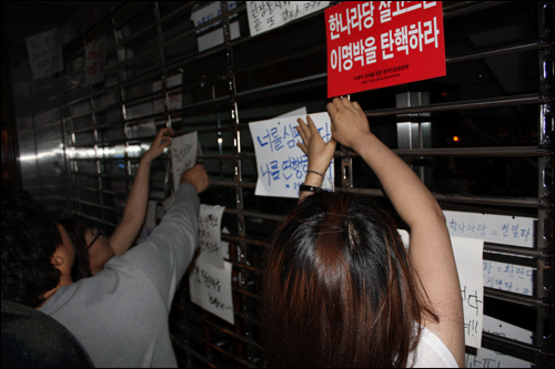  고시강행에 성난 시민들이 한나라당 대구시당 문 앞에 규탄 글귀를 붙이고 있다.