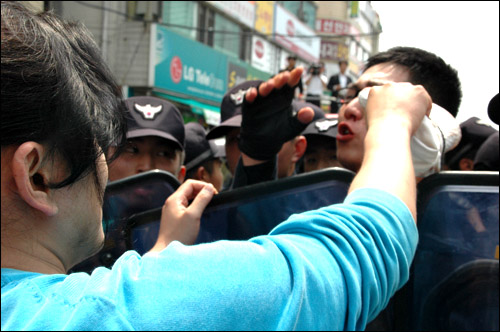  27일 오전 한나라당 경남도당 사무실을 점거농성한 대학생들을 연행하는 과정에서 한 전경대원이 코피를 흘리자 민주노총 한 조합원이 닦아주고 있다.