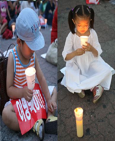 정부의 고시강행을 규탄하는 촛불 집회가 열리고 있는 철당간 광장 일원에서 아이들이 촛불에 소망을 담고 보내고 있다. 이명박 정부는 강경진압 과정에서 초등학생부터 81세 노인에 이르기까지 무차별적으로 연행함으로써 국민들의 더 큰 반발을 사고 있다. 