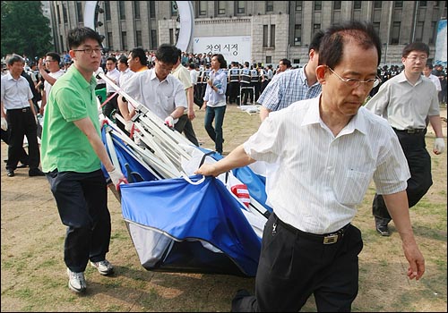  경찰과 서울시 용역 직원들이 27일 오후 시청 앞 서울광장에서 미국산 쇠고기 수입반대 농성을 벌이던 각 단체들의 천막을 강제 철거하고 있다.