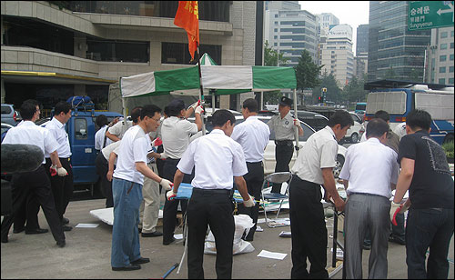  서울시청과 용역 직원 70여명이 28일 오전 서울광장에 설치돼 있던 천막과 집기 등을 철거하고 있다.  