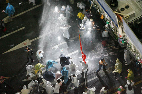 28일 저녁 서울시청 인근 태평로에서 촛불집회를 마친 시위대가 청와대 방향으로 진출을 시도하며 이들을 막고 있는 전경차를 밧줄에 묶어 끌어내려하자 경찰이 살수차를 동원해 물대포를 쏘고 있다.