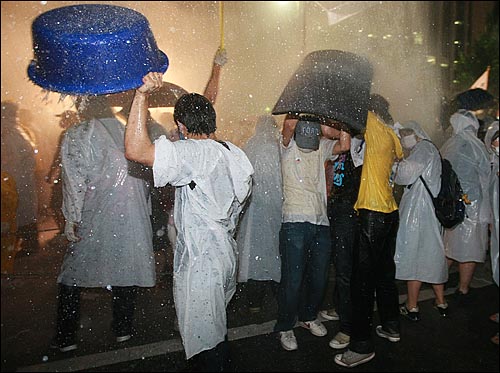 28일 저녁 서울시청 앞에서 촛불집회를 마친 시위대가 프레스센터 앞에서 청와대로 행진을 시도하자 경찰이 살수차로 물을 뿌리고 있다.