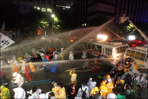 '6.28 반민주정권 심판의 날 범국민촛불대행진'에 참석한 시민, 학생들이 28일 밤 서울 광화문우체국앞 종로거리에서 청와대를 향해 행진을 시도하며 경찰버스를 끌어내려하자 경찰이 살수차로 물을 뿌리고 있다.