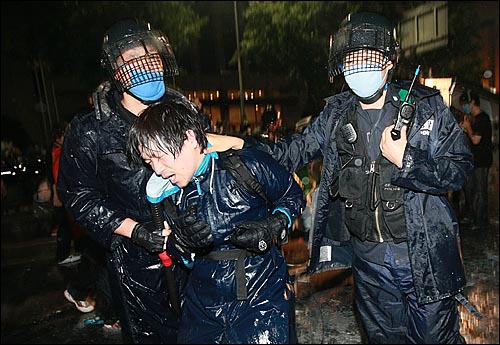 지난 2008년 6월 29일 새벽 서울 프레스센터 앞에서 미국산쇠고기 수입위생조건 장관고시에 반대하는 학생, 시민들이 경찰들과의 격렬한 대치를 벌이던 가운데 경찰의 강제진압이 시작되자 한 시민이 경찰들에게 강제연행되고 있다.