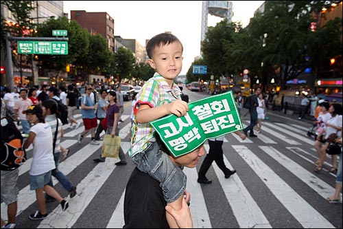 집회에 참가하기 위해 나온 한 시민이 아이를 어깨에 태운 채 종로2가 탑공공원앞 횡단보도를 걸어가고 있다.