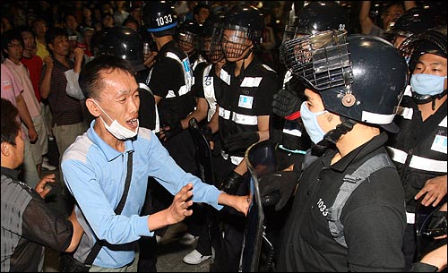 29일 오후 미국산 쇠고기 수입반대 촛불문화제가 열릴 예정인 서울시청 앞 광장을 경찰이 원천봉쇄한 가운데, 종각네거리에 집결해 농성을 벌이던 시민들이 30일 새벽 해산 작전에 나선 경찰에 항의하고 있다.