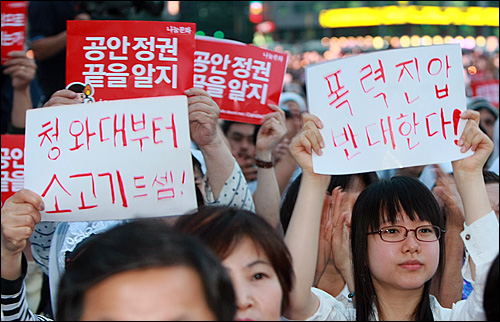  학생과 시민들이 30일 저녁 서울 시청앞 광장에서 천주교정의구현전국사제단 주최로 열린 비상 시국미사에서 참석하여 미국산쇠고기 장관 고시 반대와 촛불집회에 강경 대응하는 공권력에 반대하며 손피켓을 들어보이고 있다.