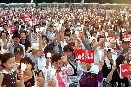 2008년 7월 1일 저녁 서울시청앞 광장에서 천주교정의구현전국사제단이 주최한 시국미사에서 참석자들이 '대한민국 헌법 제1조'를 부른 뒤 촛불을 높이 들고 환호하고 있는 모습. 
