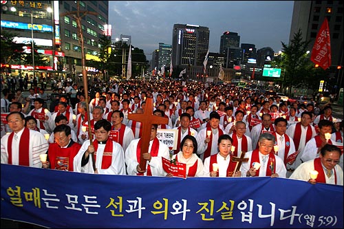 3일 저녁 서울시청앞 광장에서 한국기독교교회협의회 정의평화위원회와 광우병 기독교대책회의 주최로 열린 '국민존중 선언과 평화집회 보장을 위한 기독교 시국기도회'에 참석한 목사와 신도 및 일반시민들이 십자가를 앞세우고 거리행진을 시작하고 있다.