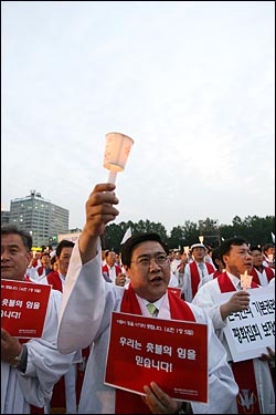  3일 저녁 서울시청앞 광장에서 한국기독교교회협의회 정의평화위원회와 광우병 기독교대책회의 주최로 열린 '국민존중 선언과 평화집회 보장을 위한 기독교 시국기도회'에 참석한 목사들이 촛불을 들고 노래를 부르고 있다.