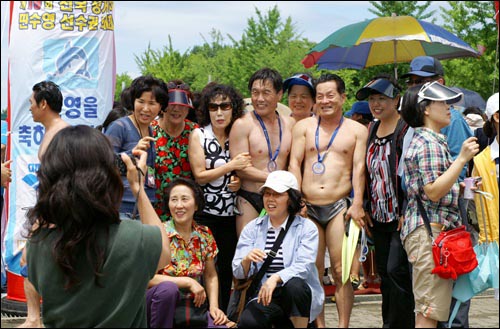 여기보세요~ "김치-" 3km 수영을 마친 선수들이 함께 온 사람들과 함께 기념촬영을 하고 있다. 서울시 흑석동 흑석체육센터 '모닝세븐' 회원들.