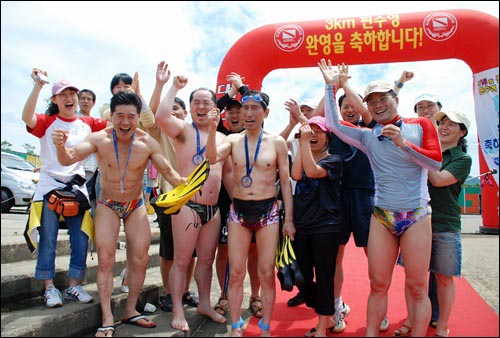 해냈어요! 3km 수영을 끝낸 선수와 응원단들이 '파이팅'을 외치고 있다. 서울시 사당동 문화센터 '사당동 물개들' 회원들.