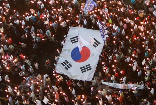 학생, 시민, 종교인, 정치인들이 5일 저녁 서울 시청 앞 광장에서 열린 '국민승리선언 범국민촛불대행진'을 마친 뒤 대형태극기를 들고 거리행진을 시작하고 있다.