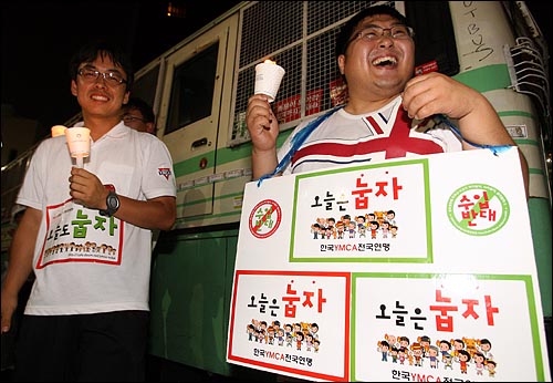 5일 저녁 '국민승리선언 범국민촛불대행진'에 참석한 한국YMCA전국연맹 '눕자' 운동 회원들이 경찰버스앞에서 촛불을 들고 서 있다.