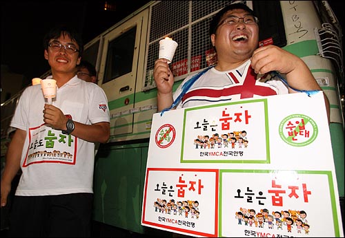  5일 저녁 '국민승리선언 범국민촛불대행진'에 참석한 한국YMCA전국연맹 '눕자' 운동 회원들이 경찰버스앞에서 촛불을 들고 서 있다.