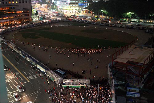  7일 저녁 한미 쇠고기 재협상 촉구 제61차 촛불문화제가 열린 서울시청앞 광장을 경찰이 봉쇄한 가운데, 촛불집회 참가자들이 가두로 나가지 못한 채 경찰버스로 둘러싸인 광장을 돌고 있다.