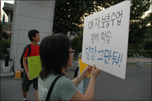 청소년인권단체 아수나로 회원들이 마산 용마고 정문 앞에서 피켓을 들고 서있다.